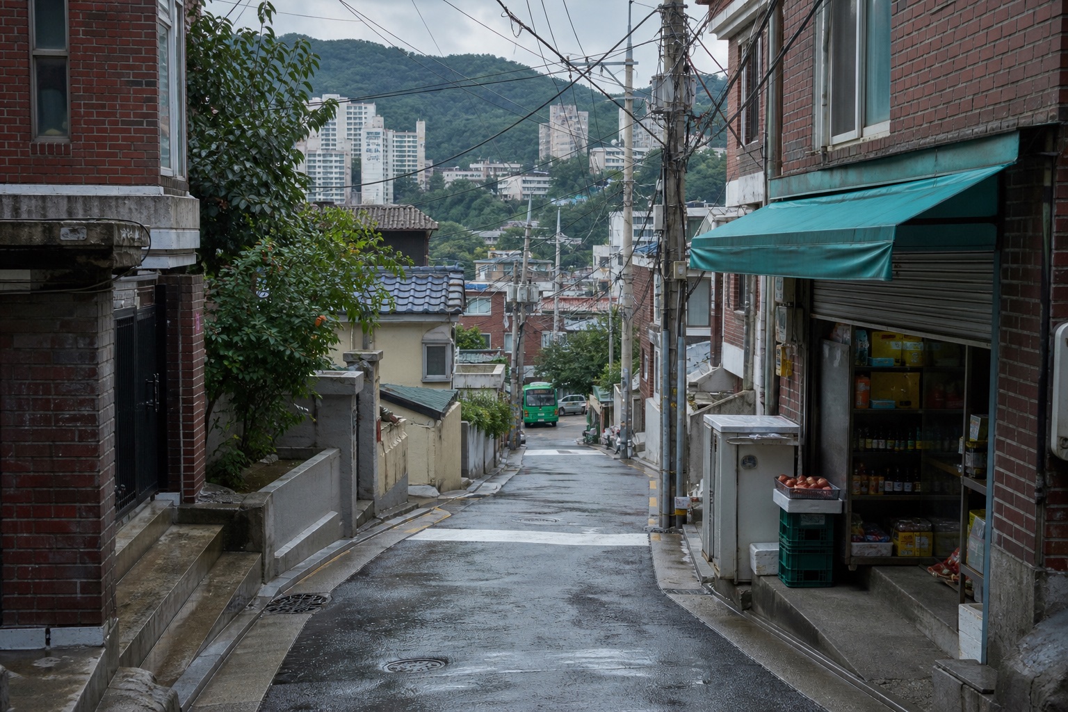 비 온 뒤 서울의 언덕 골목과 동네 가게, 멀리 보이는 아파트와 산
